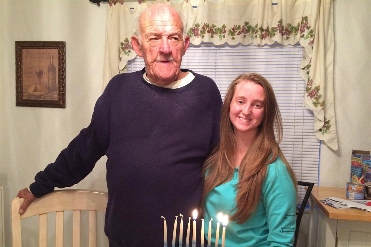 Ashley and her poppy lighting Hanukkah candles